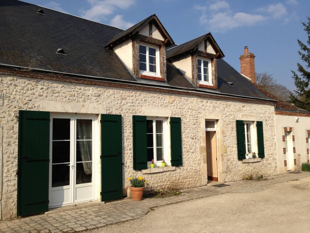 Façade en pierre avec fenêtres traditionnelles et volets verts — Dagicour
