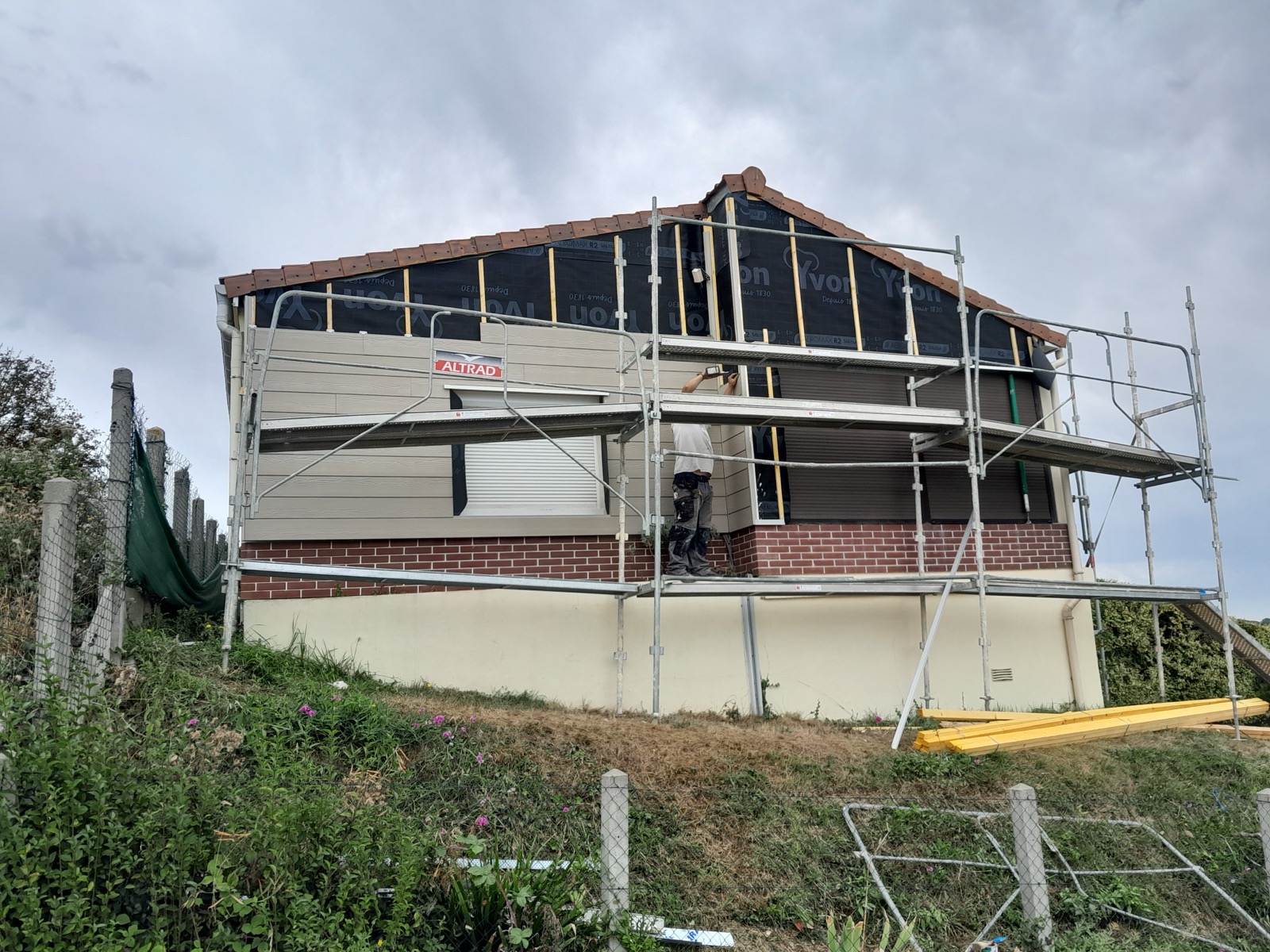 Bardage composite presque terminé sur pignon avec soubassement brique — chantier Dagicour