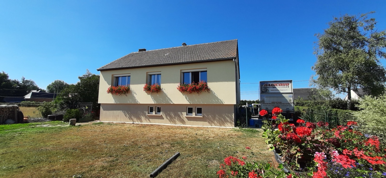 Maison rénovée en isolation thermique extérieure avec enduit beige et jardin fleuri — Dagicour Seine-Maritime