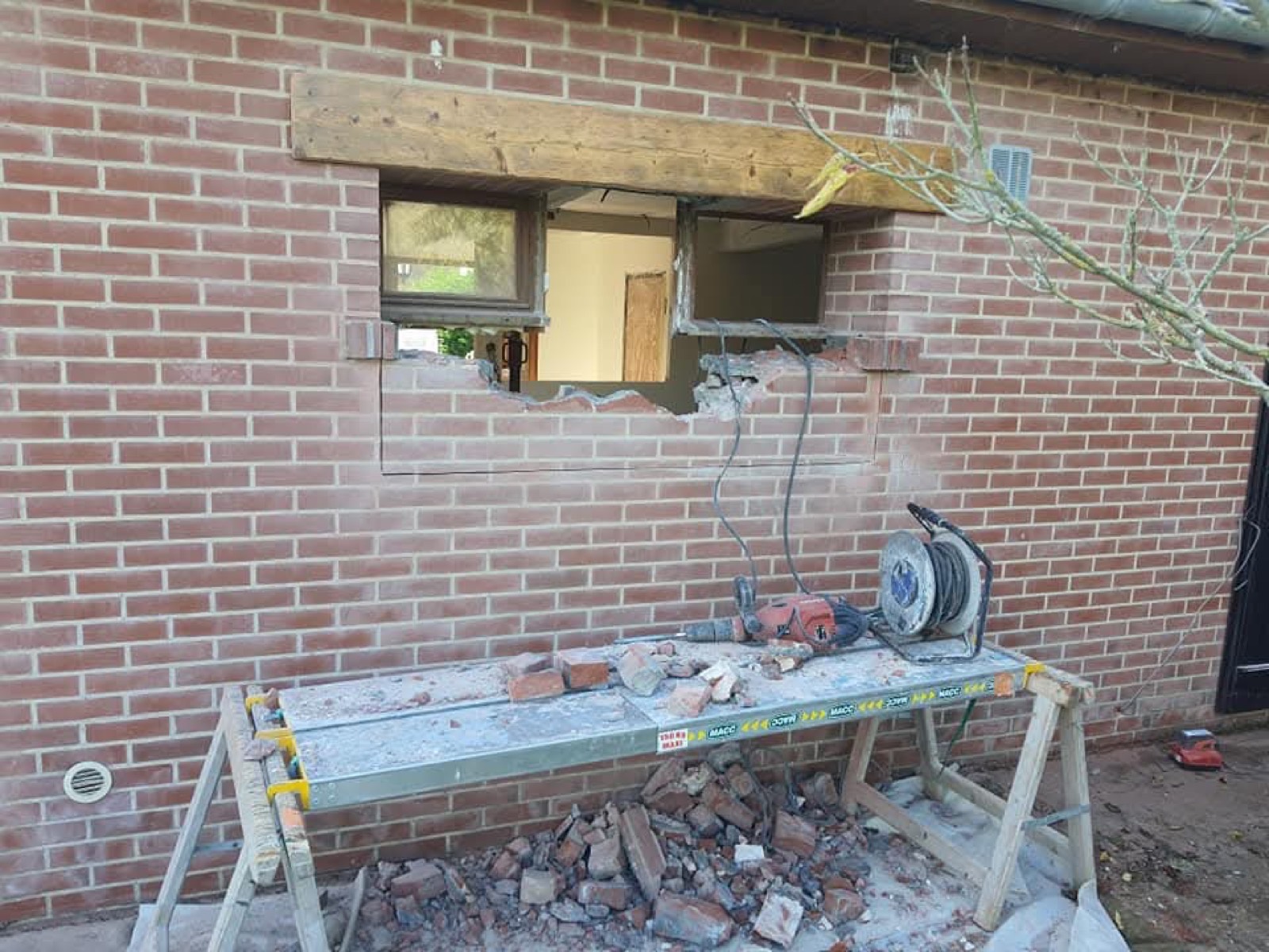 Démolition à la meuleuse pour agrandir une ouverture de fenêtre sur mur en briques — chantier Dagicour