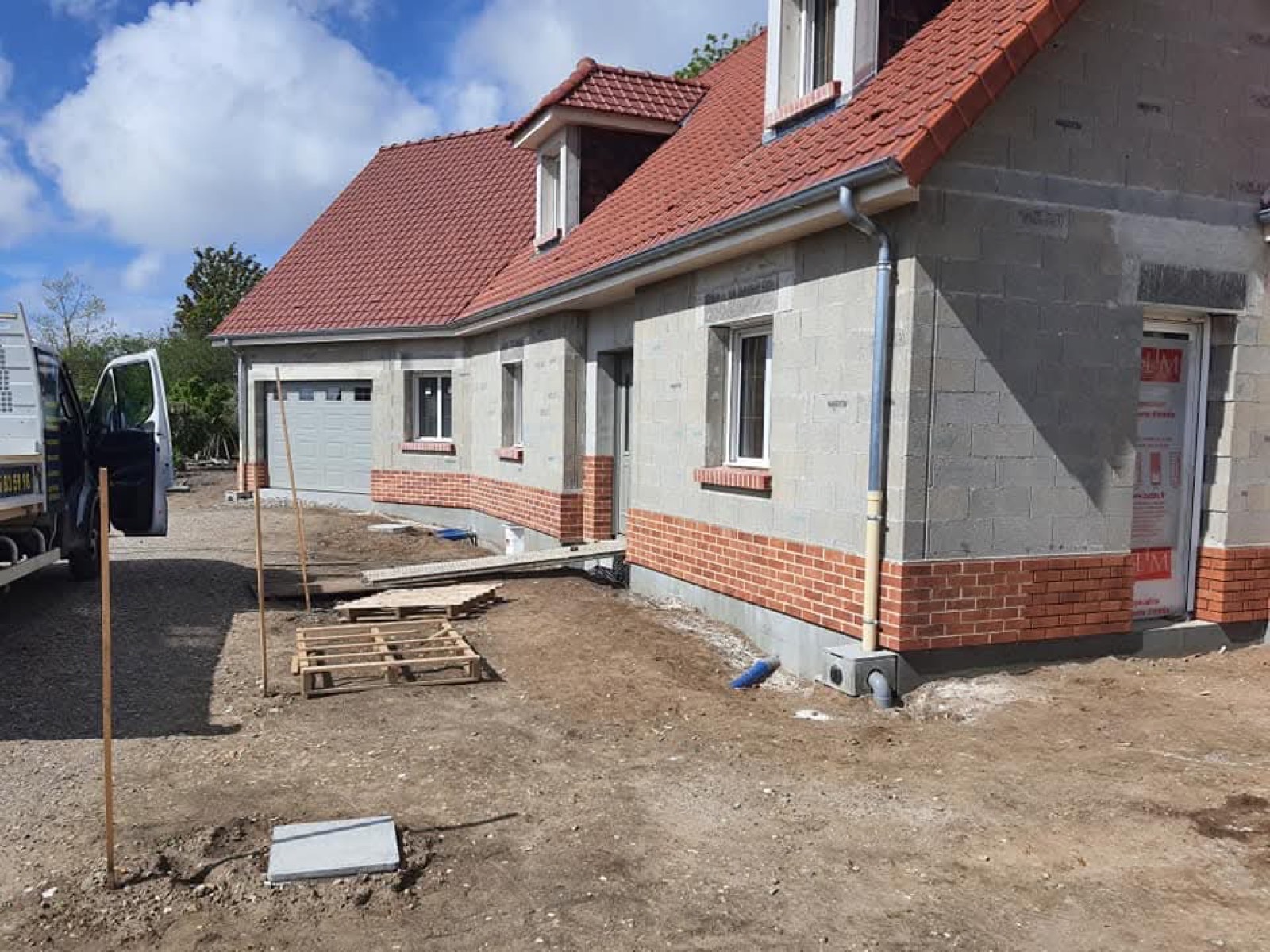 Construction neuve : élévation en parpaings et soubassement en briques de parement sur une maison en Seine-Maritime