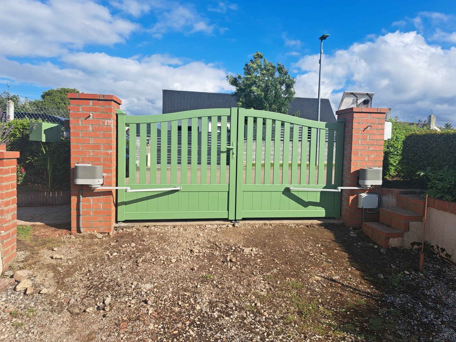 Détail des bras de motorisation d'un portail aluminium vert — installation Dagicour Seine-Maritime