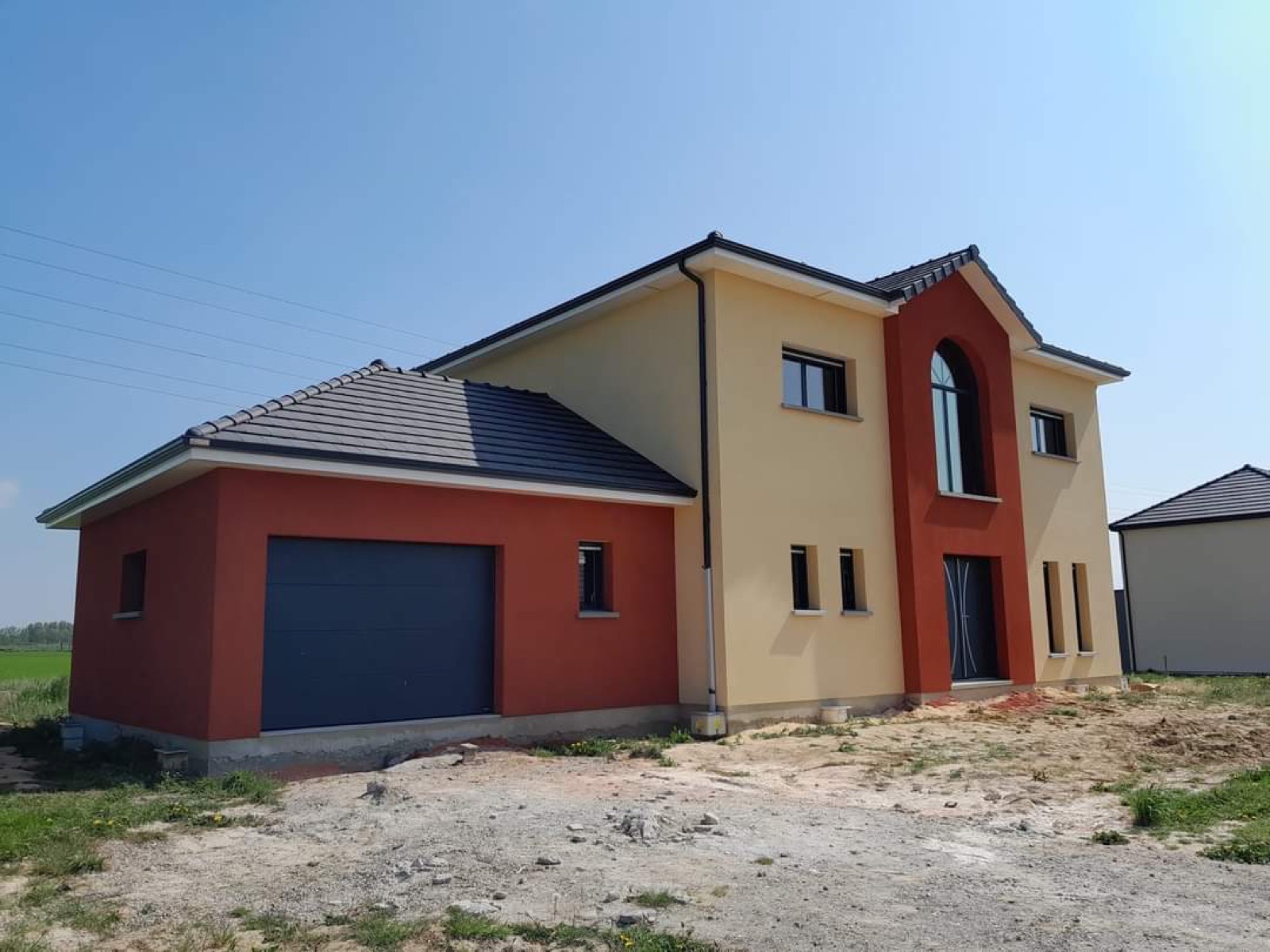 Maison neuve avec enduit bicolore crème et terracotta, encadrement de porte arrondi, Seine-Maritime