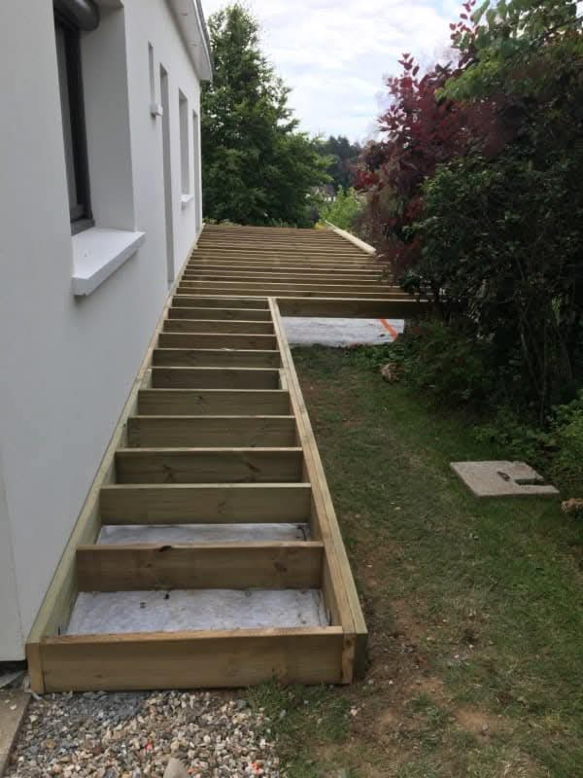 Avant : ossature de terrasse en cours de montage le long de la même villa blanche — Dagicour